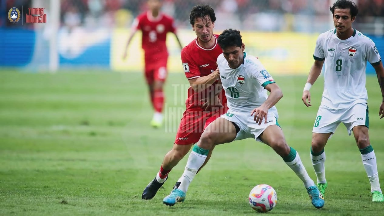 Pemain Timnas Indonesia (jersey merah) mencoba merebut bola dari penguasaan pemain Iraq (jersey putih bernomor 15) dalam laga kualifikasi Piala Dunia.