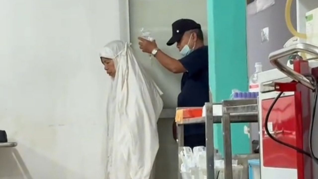 Momen Haru Nenek Tetap Salat Sementara Kakek Menemani dengan Memegang Infus di Belakang